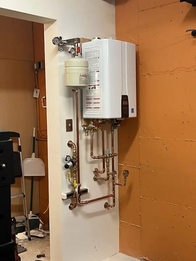 Plumbing technician inspecting water heater connections in Edwardsville